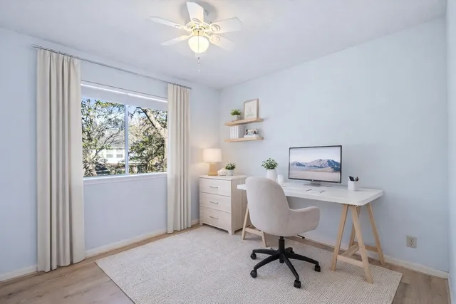 a view of a workspace with furniture and a window
