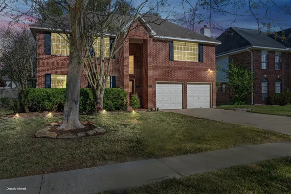 a view of a brick house with many windows next to a yard