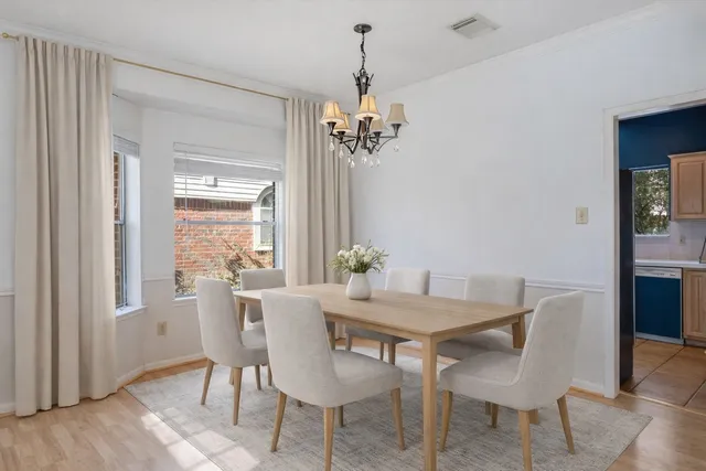a view of a dining room with furniture a chandelier and wooden floor