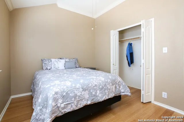 a bedroom with a bed and wooden floor
