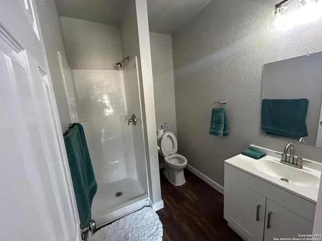 a bathroom with a sink a toilet and shower a mirror