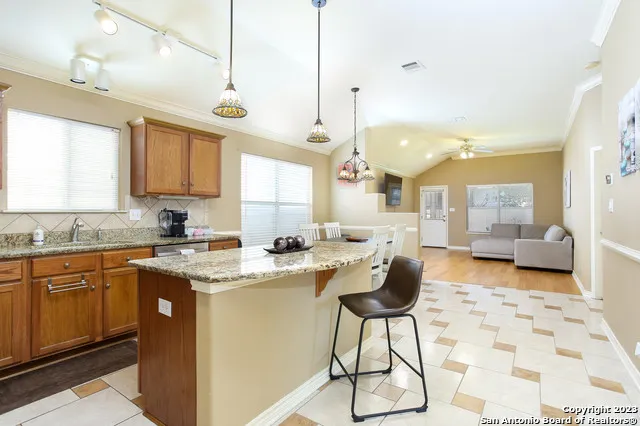 a kitchen with stainless steel appliances granite countertop a sink a stove a counter top space and cabinets