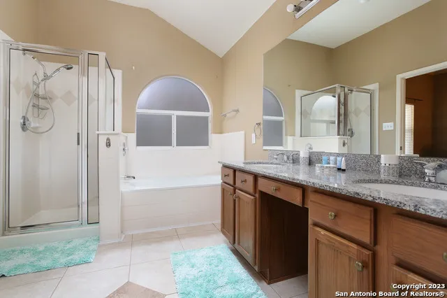 a bathroom with a granite countertop sink mirror and shower