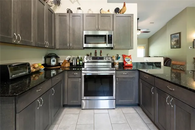 a kitchen with stainless steel appliances granite countertop a stove and a microwave