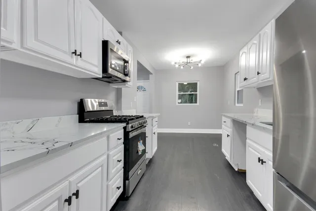 a kitchen with stainless steel appliances sink stove microwave and cabinets
