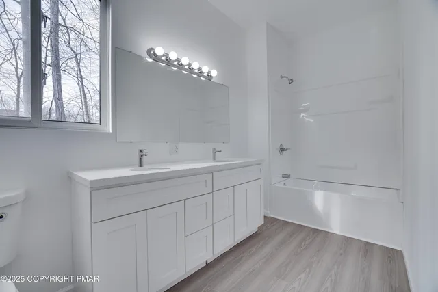 a bathroom with a sink a large mirror and shower