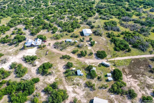 an aerial view of a house with a yard and lake view
