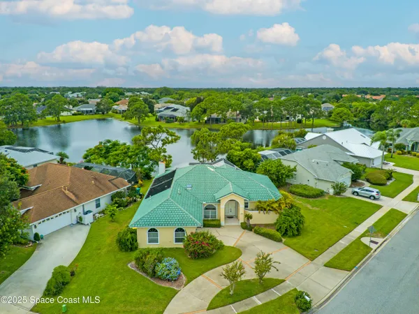 an aerial view of residential houses with outdoor space and lake view