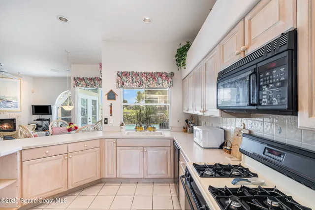 a kitchen with a sink and a large mirror next to a window