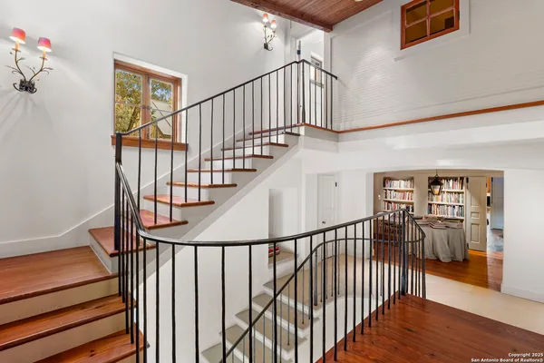 a view of staircase with railing and white walls