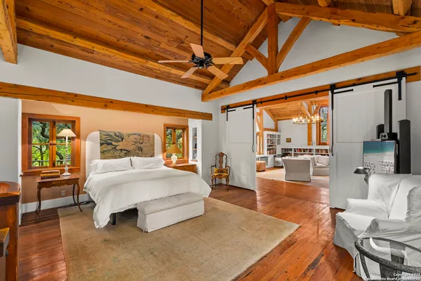 a spacious bedroom with a large bed and a wooden floor