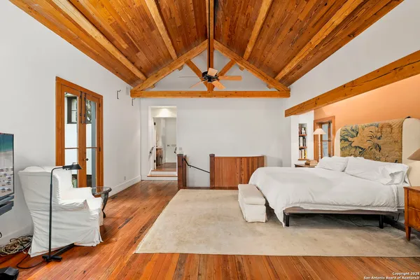 a spacious bedroom with a bed a couch and next to a window