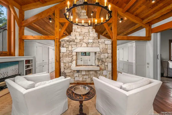 a living room with furniture a fireplace and a chandelier