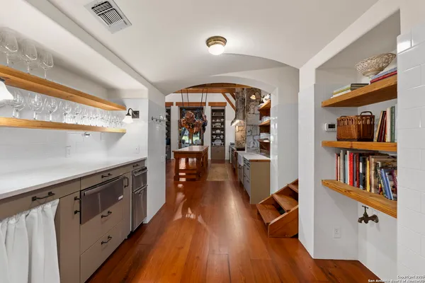 a view of a kitchen with furniture and wooden floor