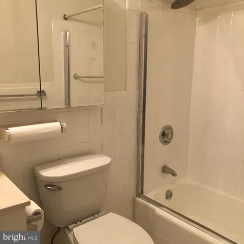 a white toilet sitting next to a bath tub shower
