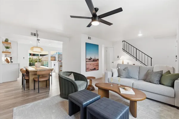 a living room with furniture a ceiling fan and a rug