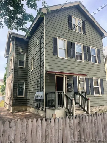 a view of a house with a window and wooden fence