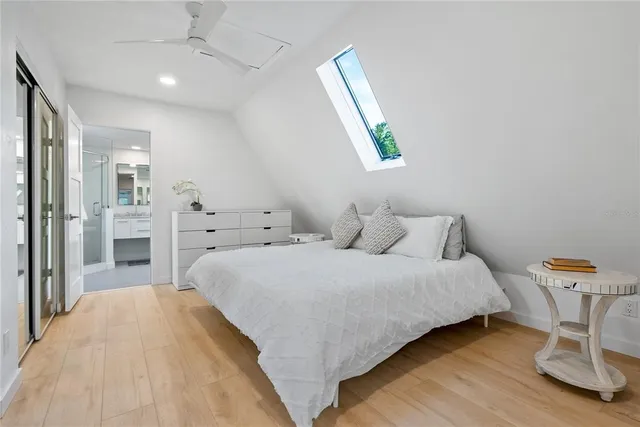 a bedroom with a bed a chandelier and mirror