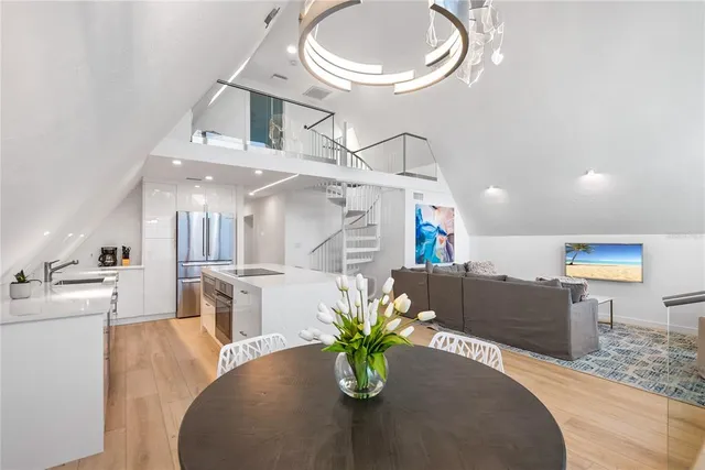 a dining room with furniture a chandelier and kitchen view