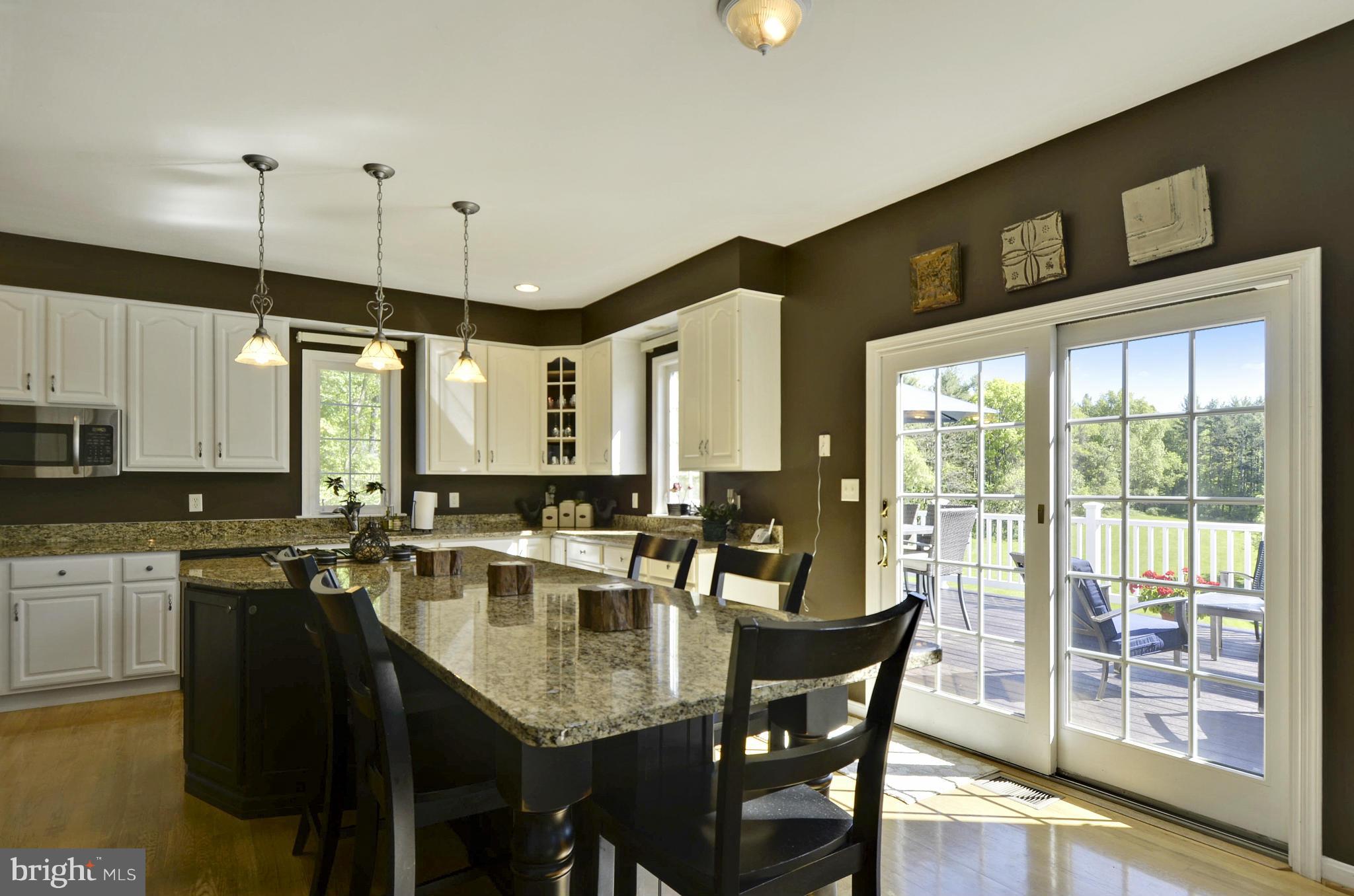 1212 Walker Road Freeland, MD 21053 - Photo 3 of 30 a kitchen with stainless steel appliances granite countertop a stove a refrigerator a sink a dining table and chairs with wooden floor