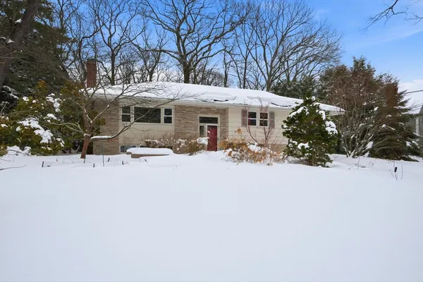 a front view of a house with a yard covered in snow