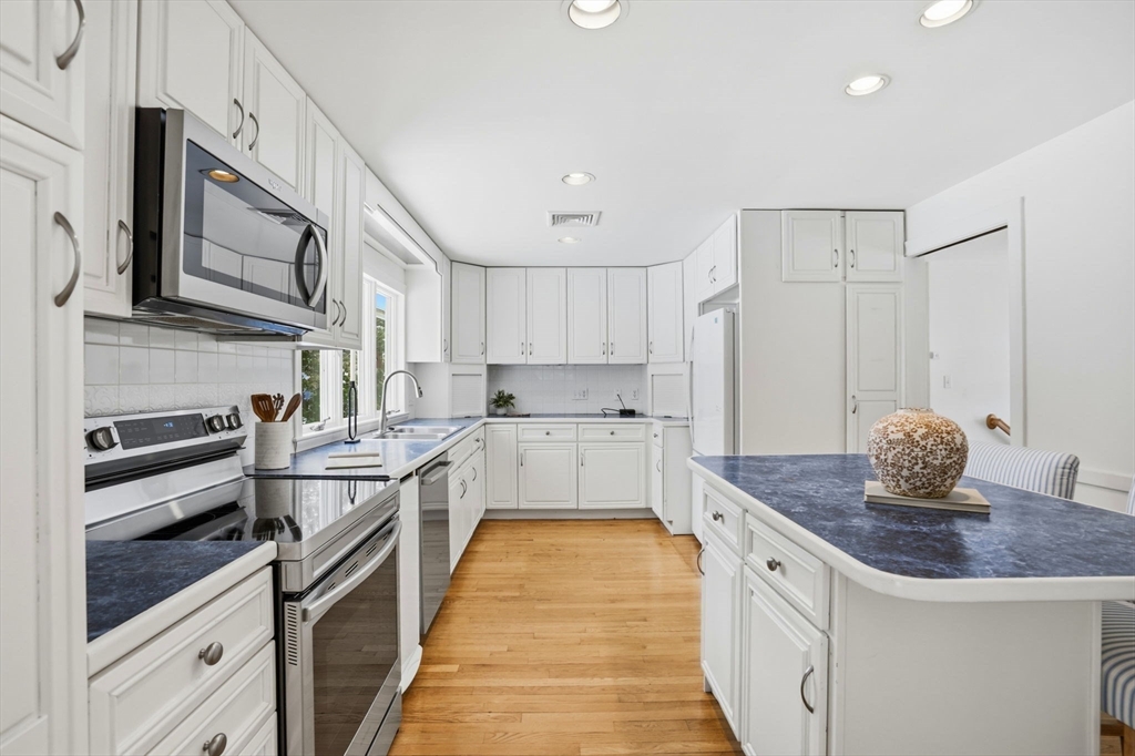 7 Baskin Road Lexington, MA 02421 - Photo 8 of 23 a kitchen with stainless steel appliances granite countertop a sink stove and refrigerator