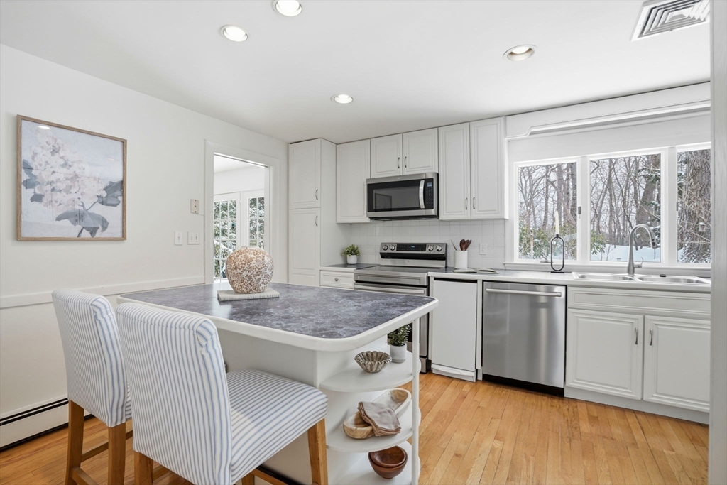7 Baskin Road Lexington, MA 02421 - Photo 9 of 23 a kitchen with stainless steel appliances granite countertop a sink dishwasher a stove a refrigerator a microwave oven with cabinets and wooden floor