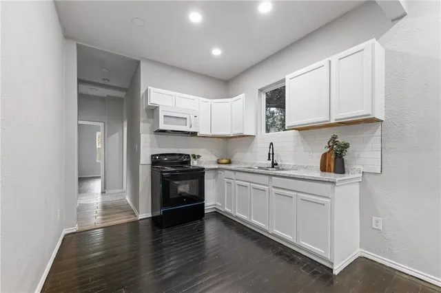 a kitchen with stainless steel appliances granite countertop a stove and cabinets