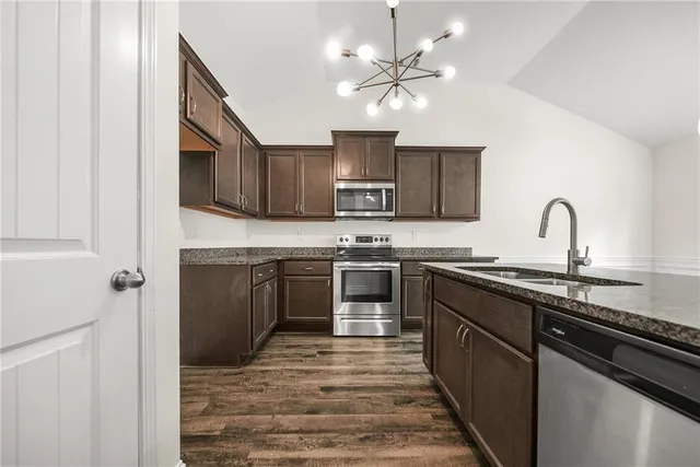 a kitchen with stainless steel appliances granite countertop a stove sink and cabinets