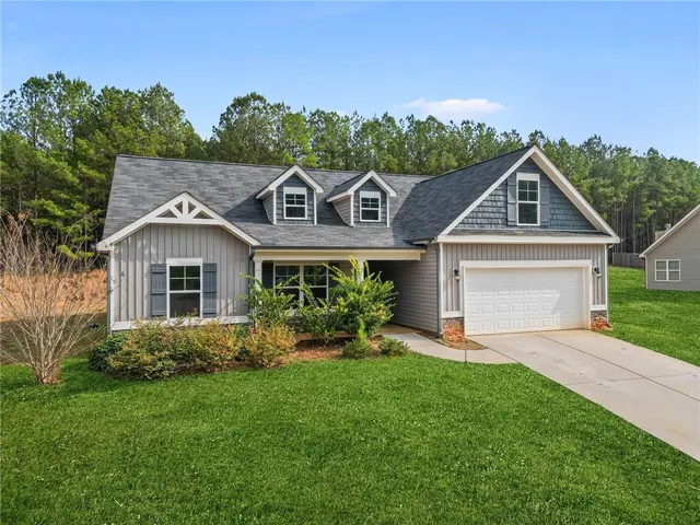 a front view of a house with a yard and potted plants