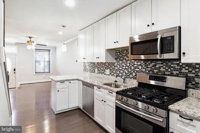 a kitchen with granite countertop a stove and a sink