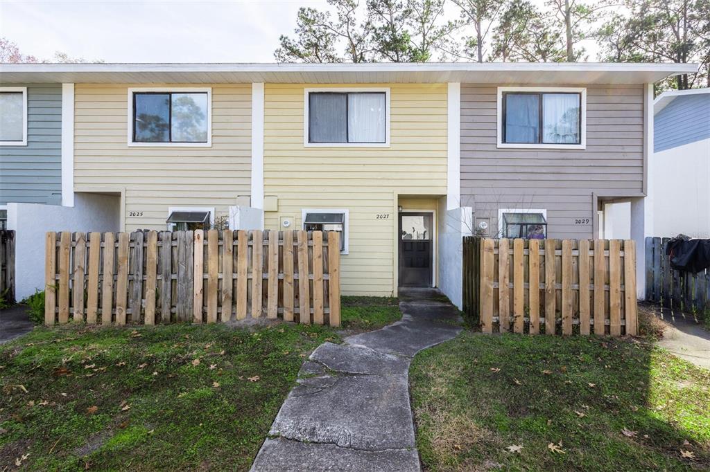 2027 Southwest 39 Way Gainesville, FL 32607 - Photo 1 of 1 a view of a house with a small yard and wooden fence