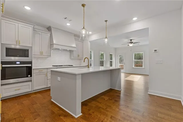a large kitchen with cabinets and wooden floor