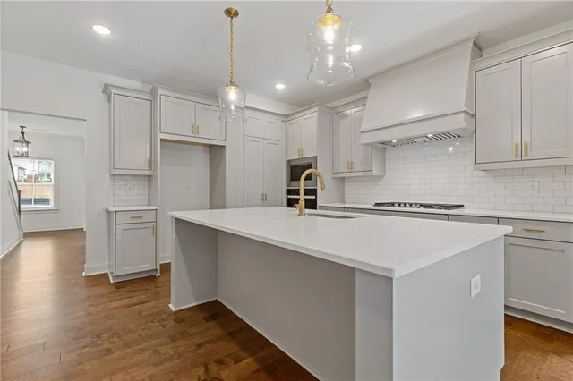 a kitchen with kitchen island a sink stainless steel appliances and cabinets
