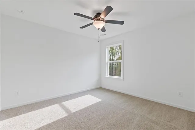 an empty room with a window and a ceiling fan