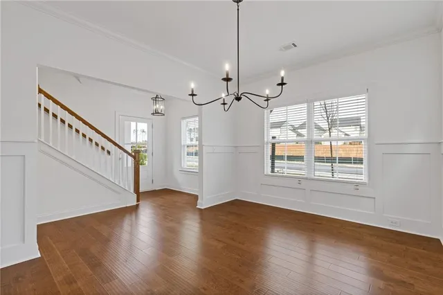 a view of an empty room with wooden floor floors and a window