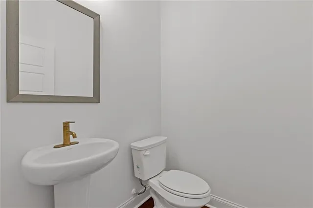 a white toilet sitting next to a bathroom sink