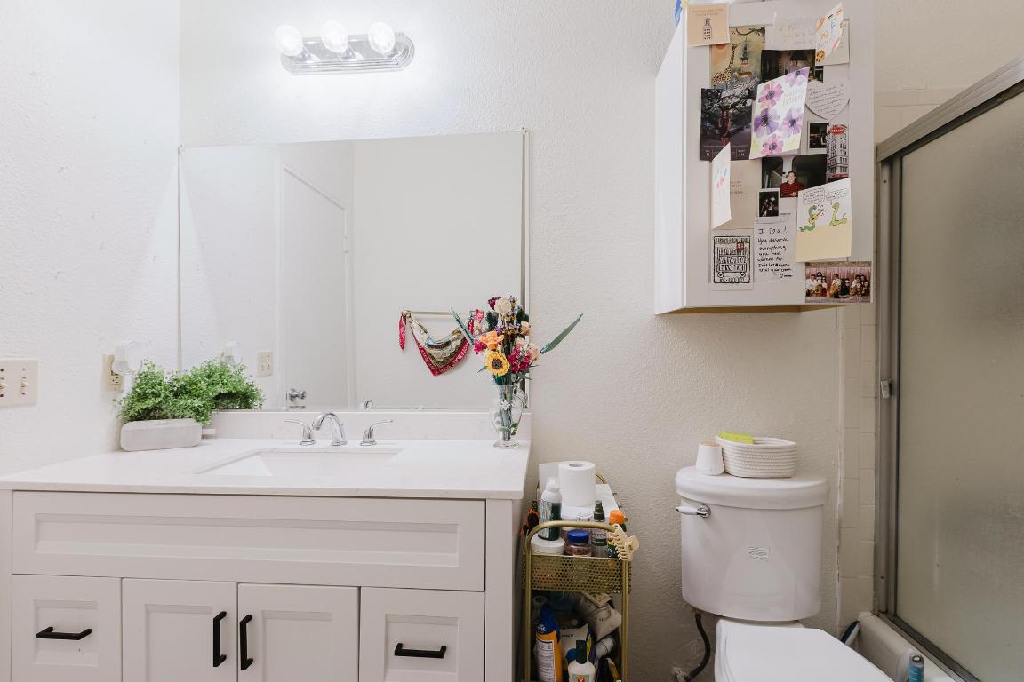 1910 Robbins Place, Unit 207 Austin, TX 78705 - Photo 12 of 28 a bathroom with a sink a toilet and mirror