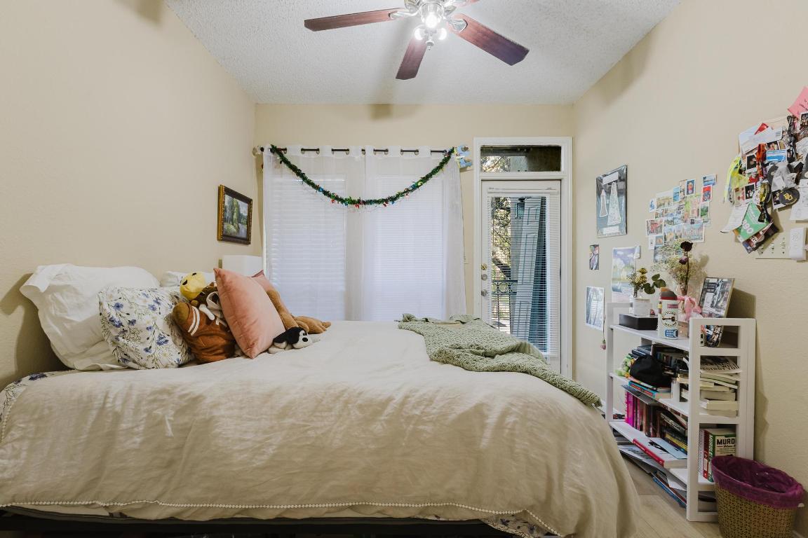 1910 Robbins Place, Unit 207 Austin, TX 78705 - Photo 13 of 28 a bedroom with a bed and a chandelier