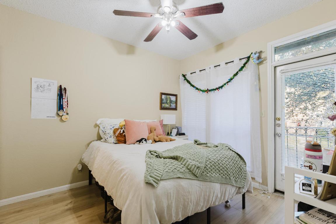 1910 Robbins Place, Unit 207 Austin, TX 78705 - Photo 14 of 28 a bedroom with a bed and a chandelier