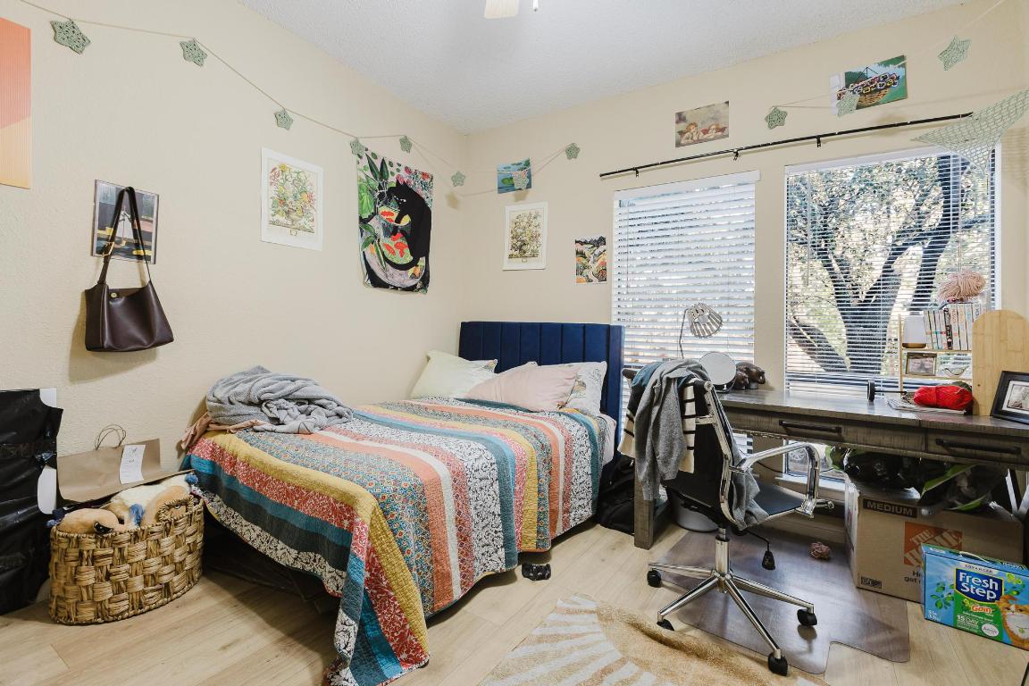 1910 Robbins Place, Unit 207 Austin, TX 78705 - Photo 18 of 28 a bedroom with a bed and wooden floor