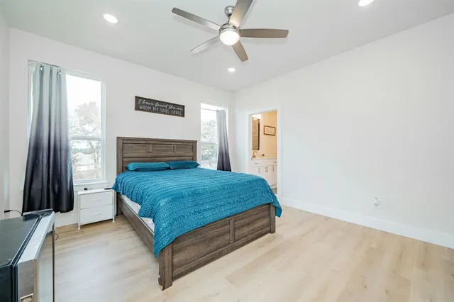 a bedroom with a bed and a flat tv screen on dresser