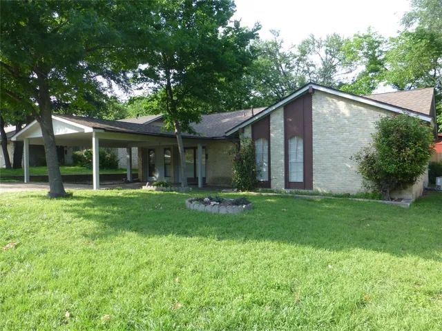 a view of a house with a yard and green space