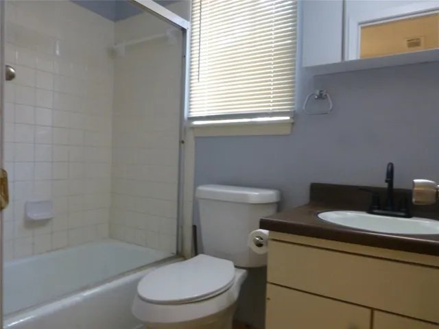 a white toilet sitting next to a bath tub
