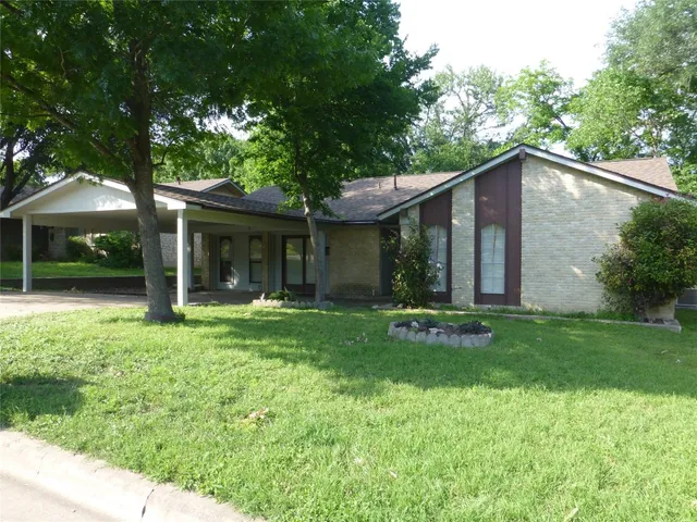 a view of a house with a yard and sitting area
