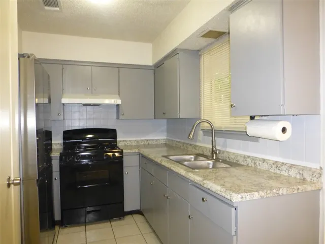 a kitchen with a sink and a stove top oven
