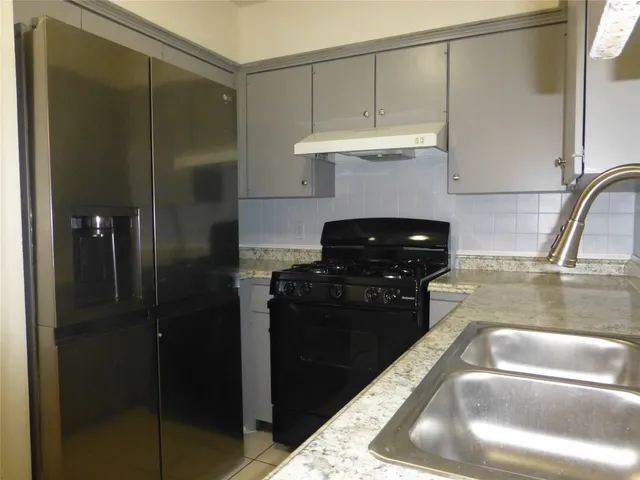 a kitchen with a refrigerator and a sink