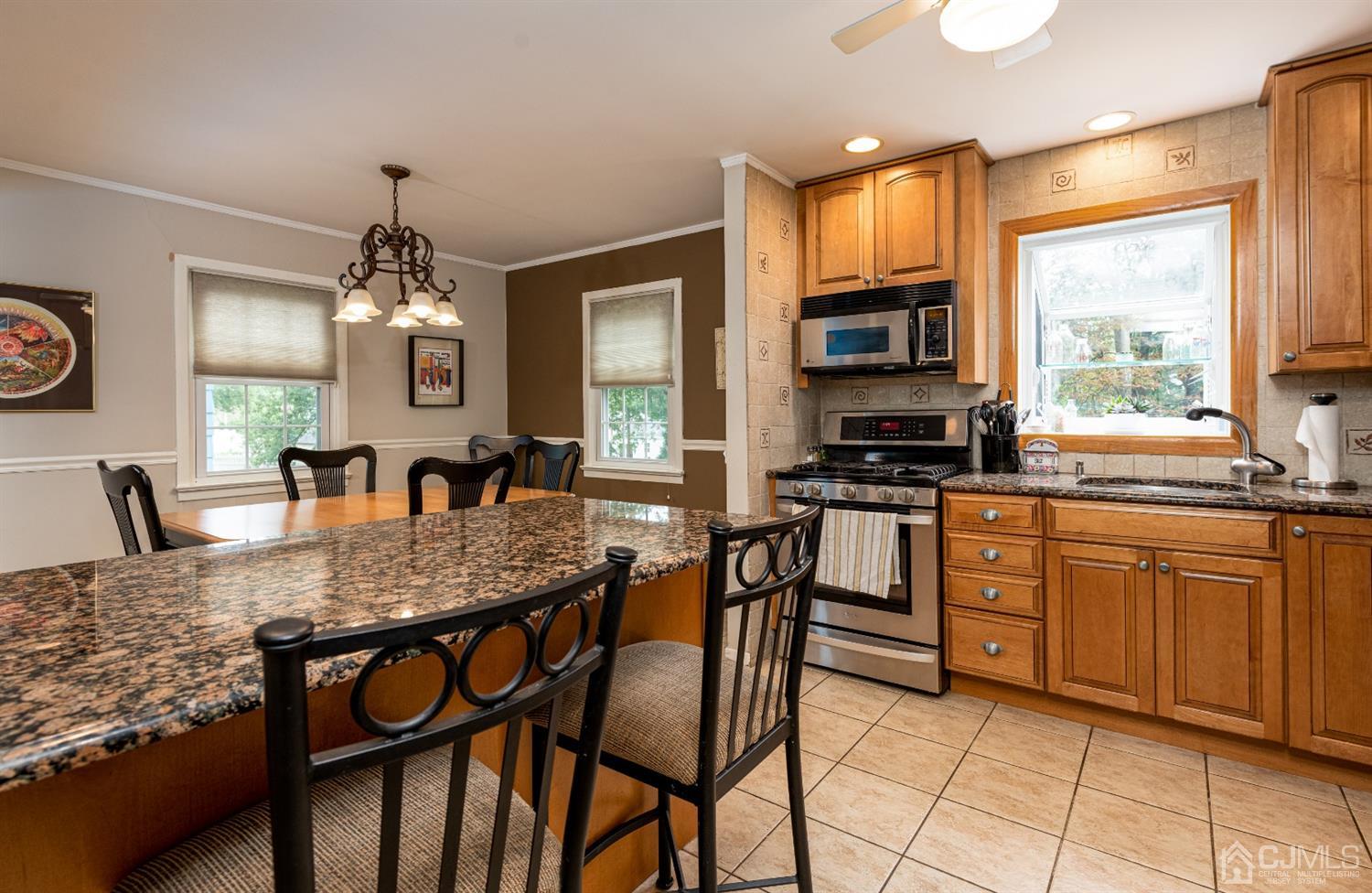 35 Larchmont Road Edison, NJ 08837 - Photo 9 of 23 a kitchen with stainless steel appliances granite countertop a stove a sink dishwasher a dining table and chairs with wooden floor