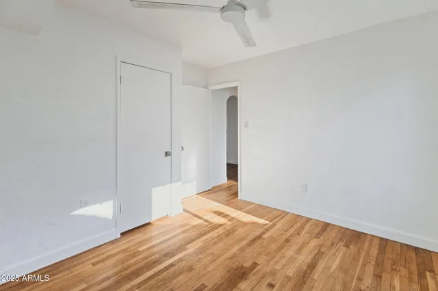 a view of empty room with wooden floor