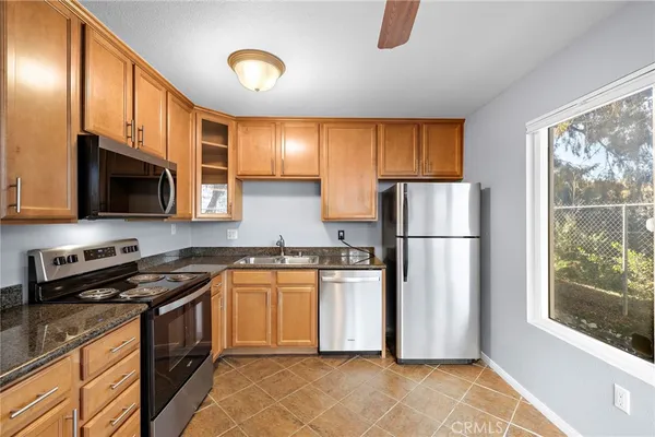 a kitchen with stainless steel appliances granite countertop a refrigerator stove top oven a sink and dishwasher